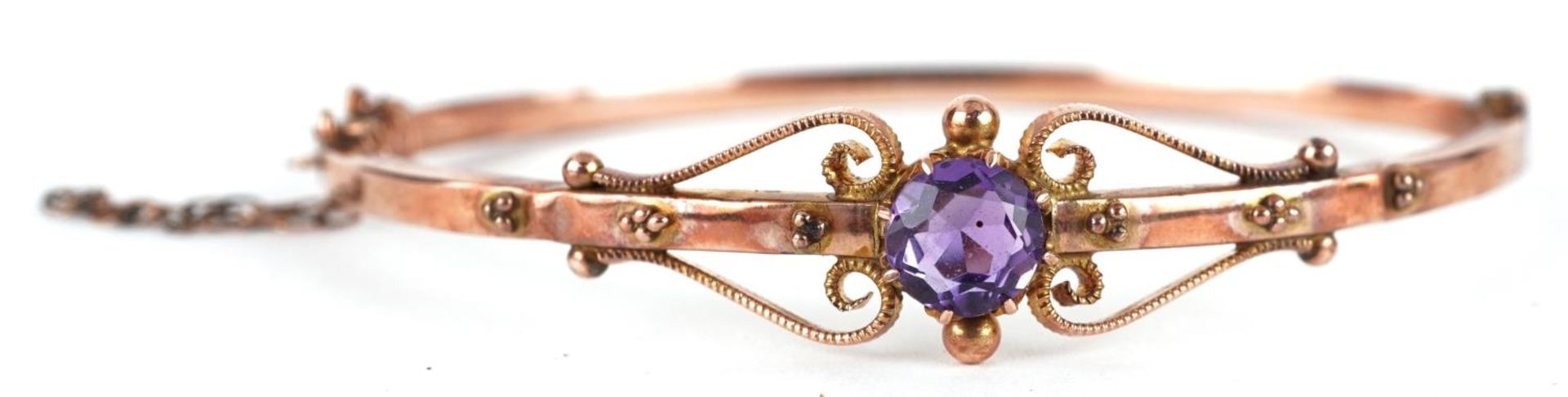 Edwardian 9ct rose gold amethyst bangle with scrolled decoration, the amethyst approximately 6.6mm