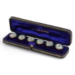 Set of six 9ct gold mounted mother of pearl and green enamel studs housed in a fitted silk and