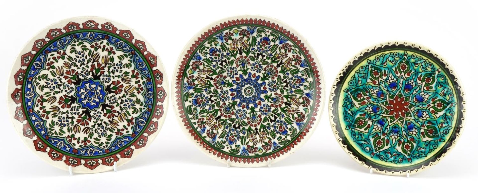 Three Turkish Kutahya pottery plates hand painted with flowers, the largest each 26cm in