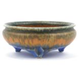 Ruskin, Arts & Crafts three footed bowl having a mottled green, orange and blue glaze, impressed