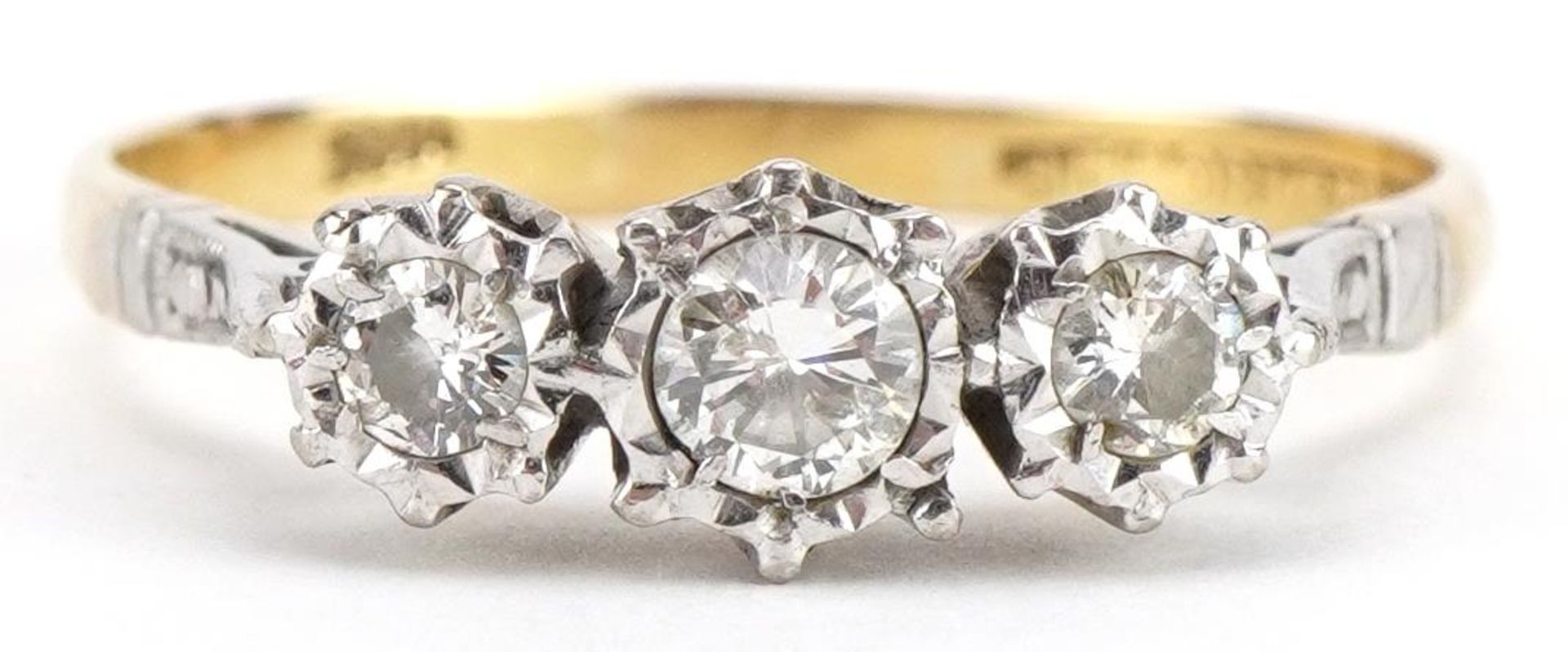 18ct gold and platinum diamond three stone ring, the largest diamond approximately 0.20 carat,