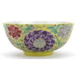 Chinese yellow ground porcelain bowl hand painted in the famille rose palette with flowers amongst