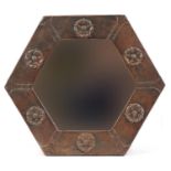 Arts & Crafts hexagonal copper wall mirror embossed with Tudor roses having bevelled glass panel,