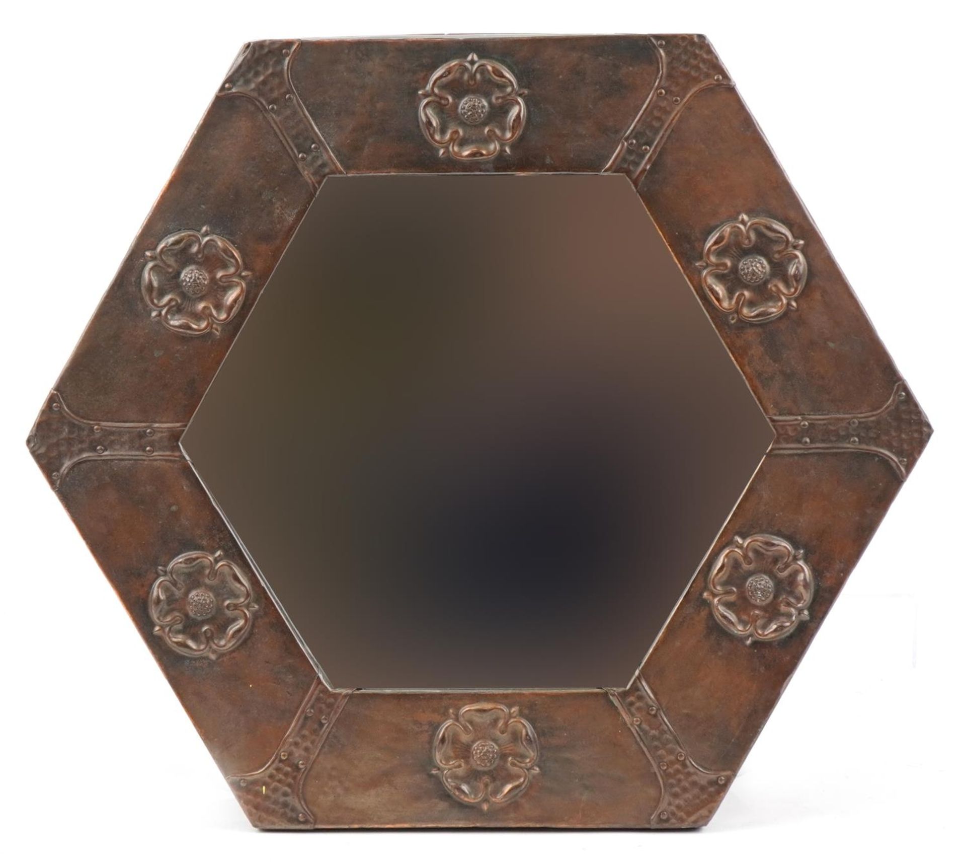 Arts & Crafts hexagonal copper wall mirror embossed with Tudor roses having bevelled glass panel,