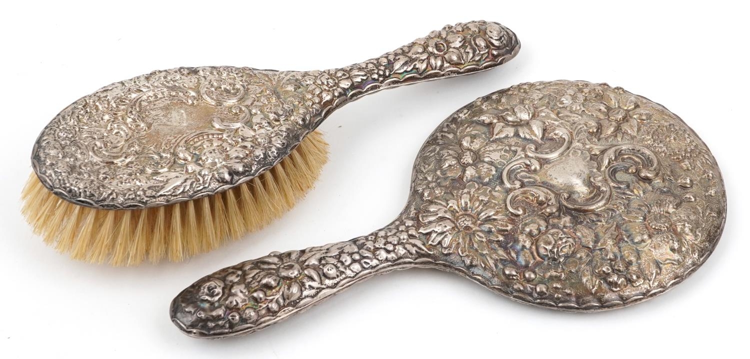 Silver backed hand mirror and clothes brush profusely embossed with flowers and foliage, S M maker's