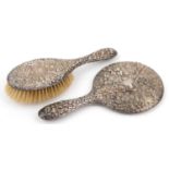 Silver backed hand mirror and clothes brush profusely embossed with flowers and foliage, S M maker's