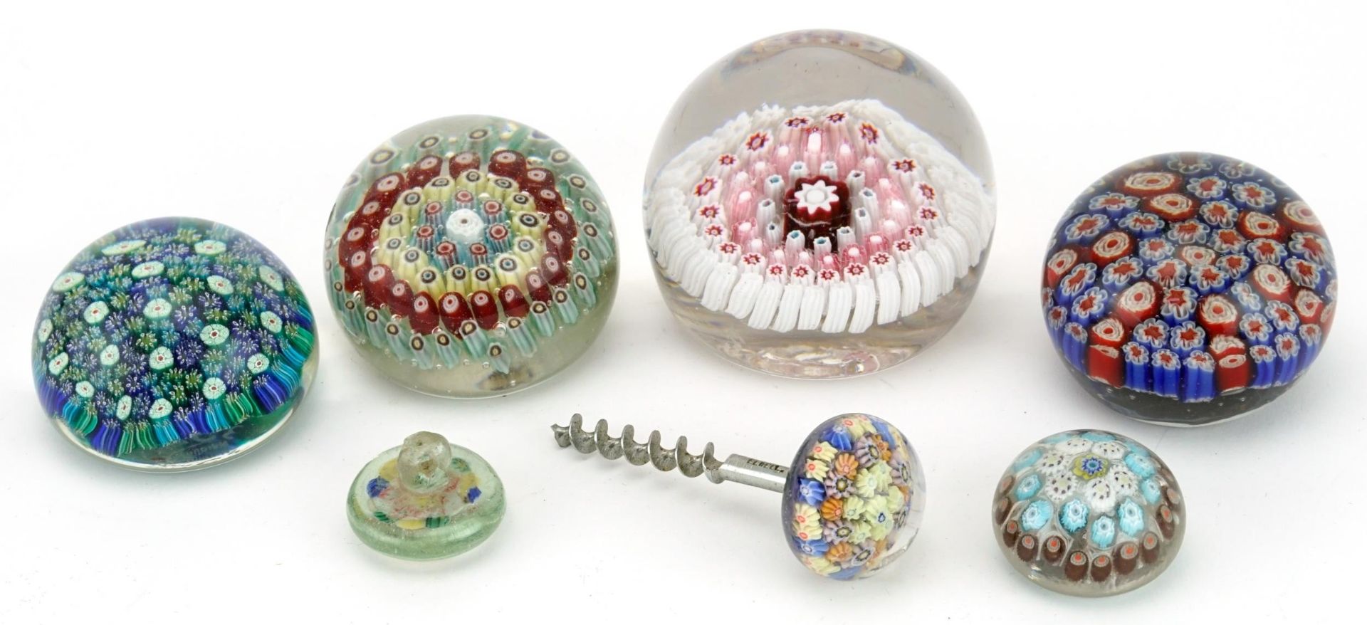 Various millefiori glass paperweights, including a button and a corkscrew, the largest 9cm in