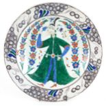 Turkish Ottoman Iznik pottery shallow dish hand painted with a figure wearing traditional dress