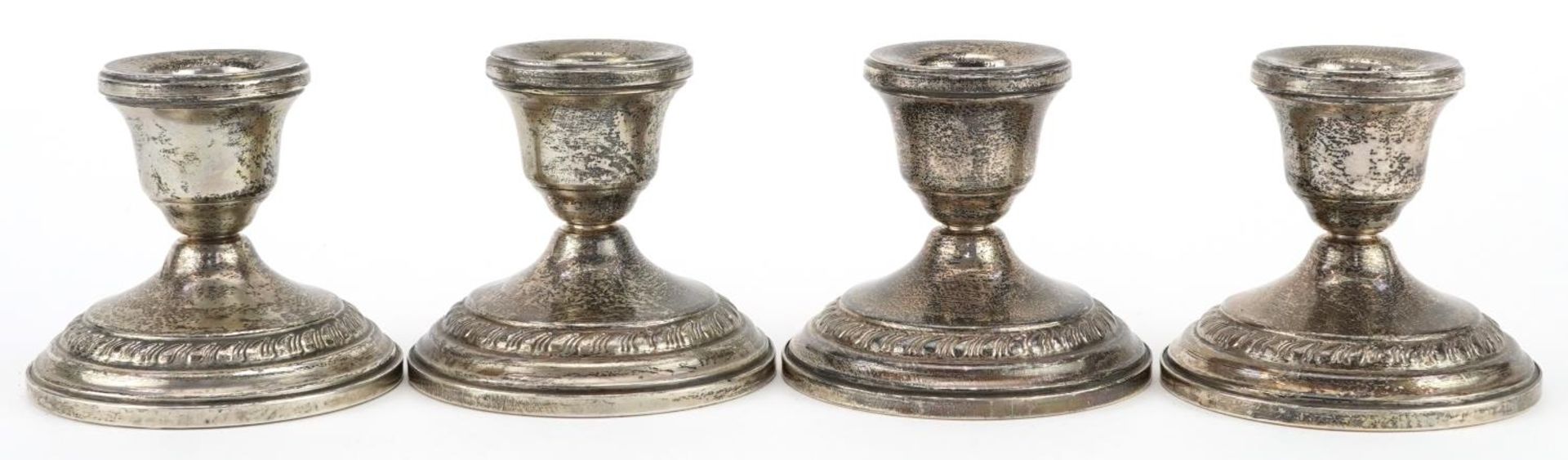 Columbia, set of four circular sterling silver weighted dwarf candlesticks, 8cm in diameter, total