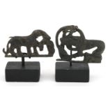 Two Persian Luristan patinated mythical animal bronzes including a buckle, each raised on stands,