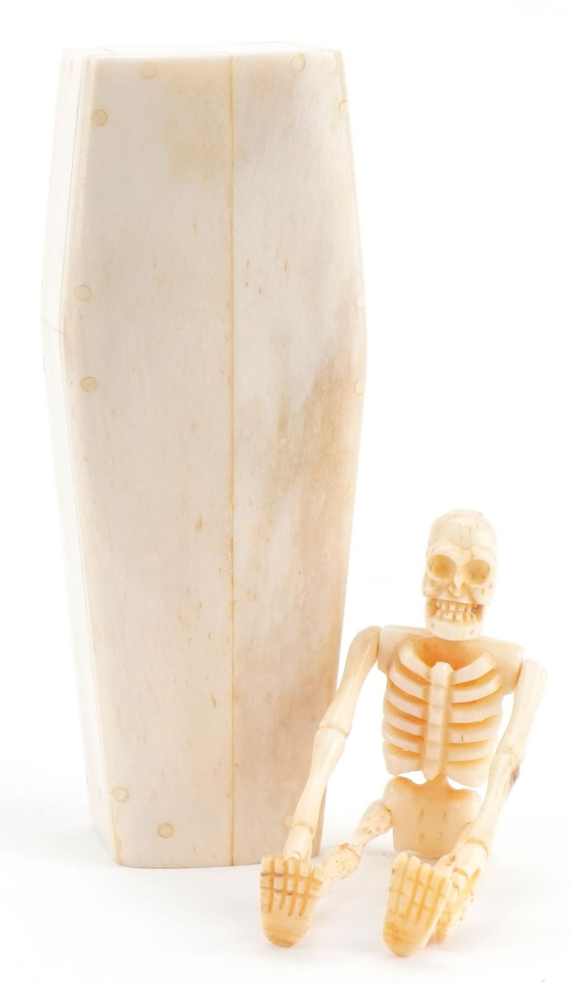 Novelty carved bone articulated skeleton housed in a sectional bone coffin, the largest 11.5cm in