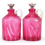 Pair of Victorian cranberry overlaid glass claret jugs with silver mounted stoppers, the bodies