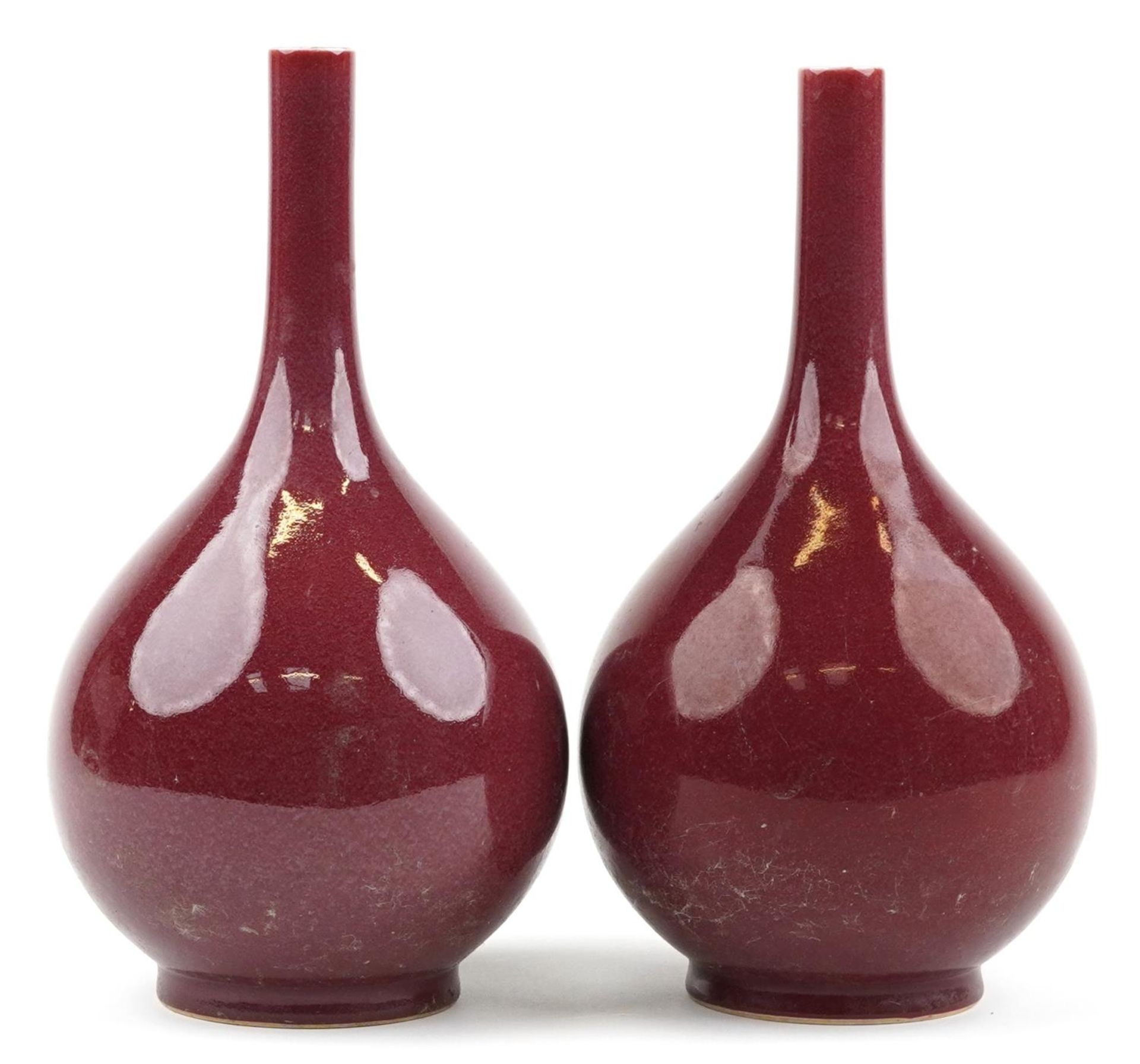 Pair of Chinese porcelain long neck bottle vases having sang de boeuf glazes, each 34cm high : For