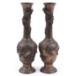 Pair of Japanese patinated bronze vases decorated in relief with dragons and birds amongst