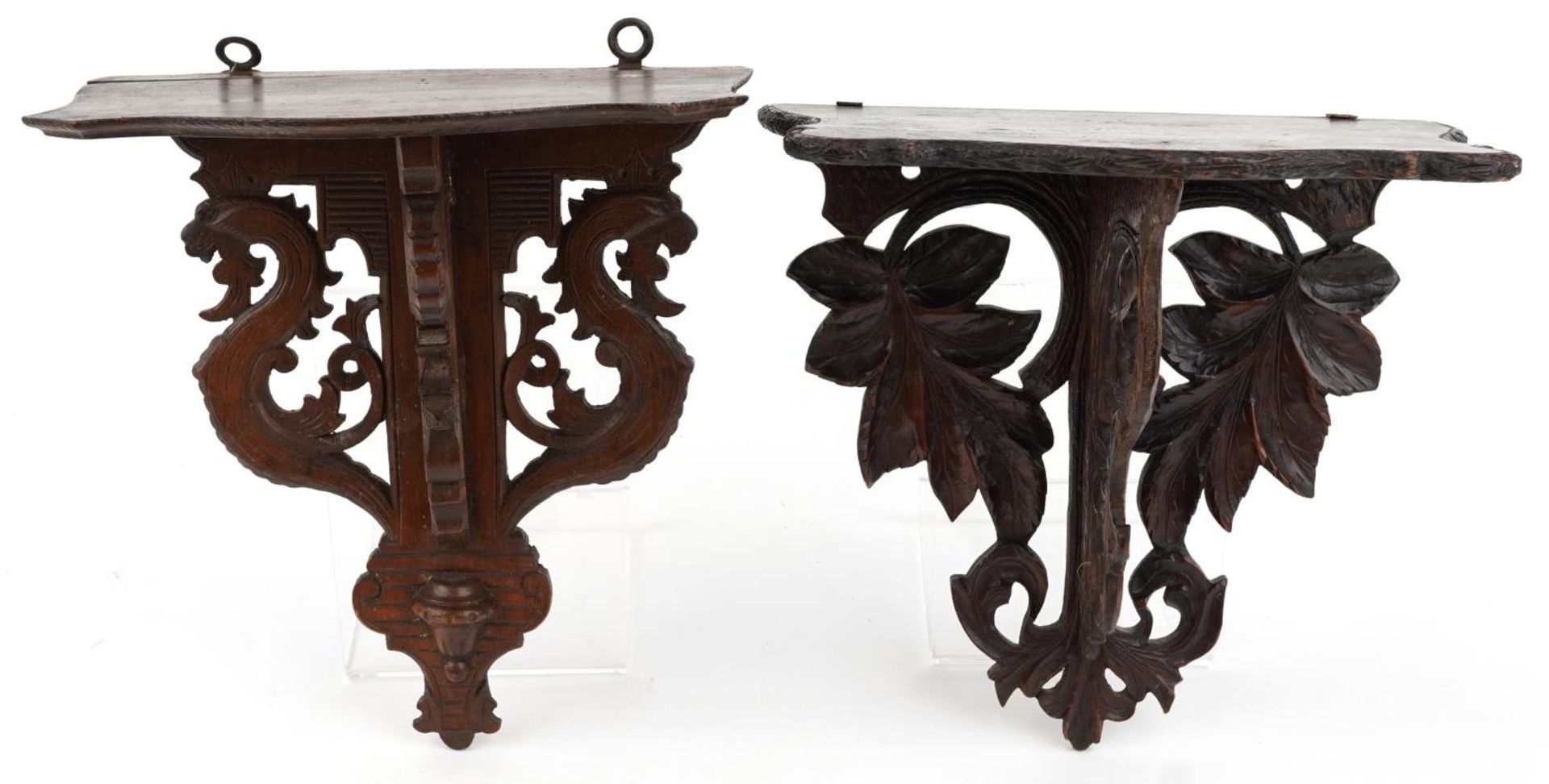 Two antique carved wood folding wall brackets including a Black Forest example, the largest 32cm