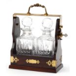 Mahogany and brass two bottle tantalus with key housing a pair of Stuart Crystal decanters with