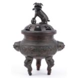 Large Chinese patinated bronze tripod censer with pierced lid surmounted with a Foo dog, cast with