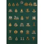 Military interest cap badges arranged in a glazed display including 14th King's Hussars, 16th The