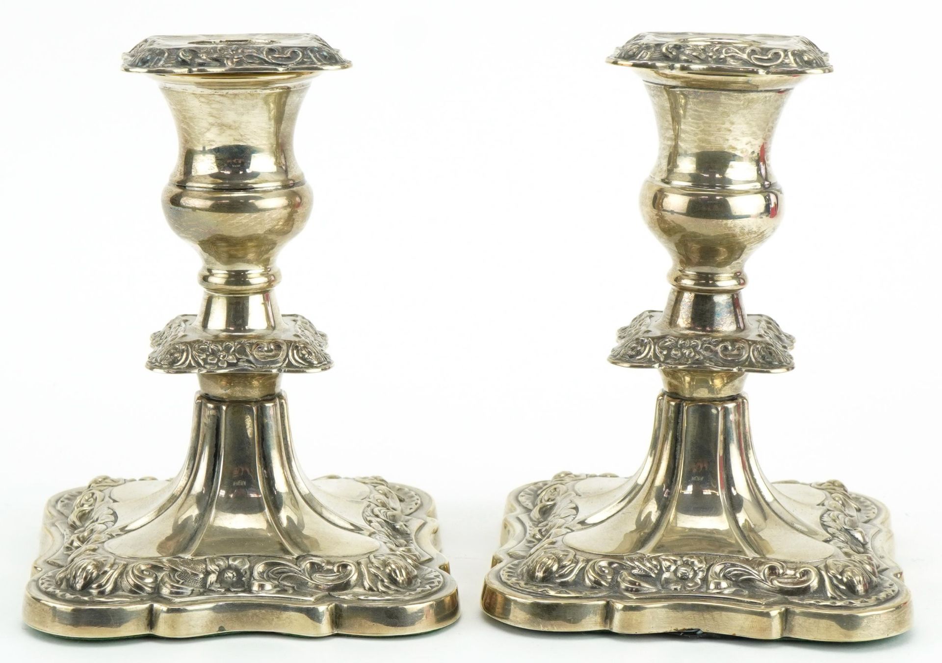 Viner's Ltd, pair of George V silver candlesticks embossed with flowers and foliage, Sheffield 1932,