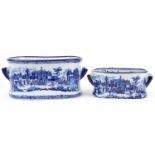 Graduated pair of blue and white porcelain planters with twin handles decorated with classical