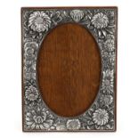 Art Nouveau silver plated copper easel photo frame profusely embossed with flower heads, 28cm x 21cm