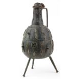 Large Middle Eastern patinated bronze three footed handled vessel, 64cm high : For further