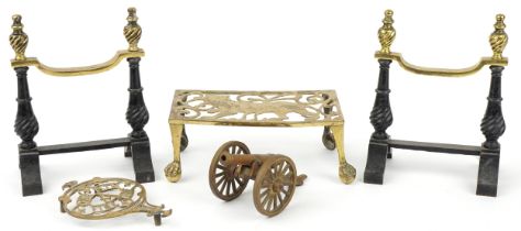 Pair of Victorian brass and cast iron firedogs, lion trivet, small brass trivet and a brass