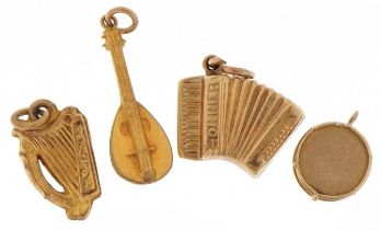 Four 9ct gold musical instrument charms comprising mandolin, accordion, drum and harp, the largest