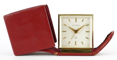 Bucherer, travelling alarm clock in a red leather case numbered 1442275 to the reverse, 6cm high x