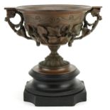 Bronzed Campana urn decorated in relief with flowers and twin handles, raised on a black slate