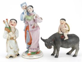 Three Chinese porcelain figures including one of a nude box on water buffalo and a Chinese