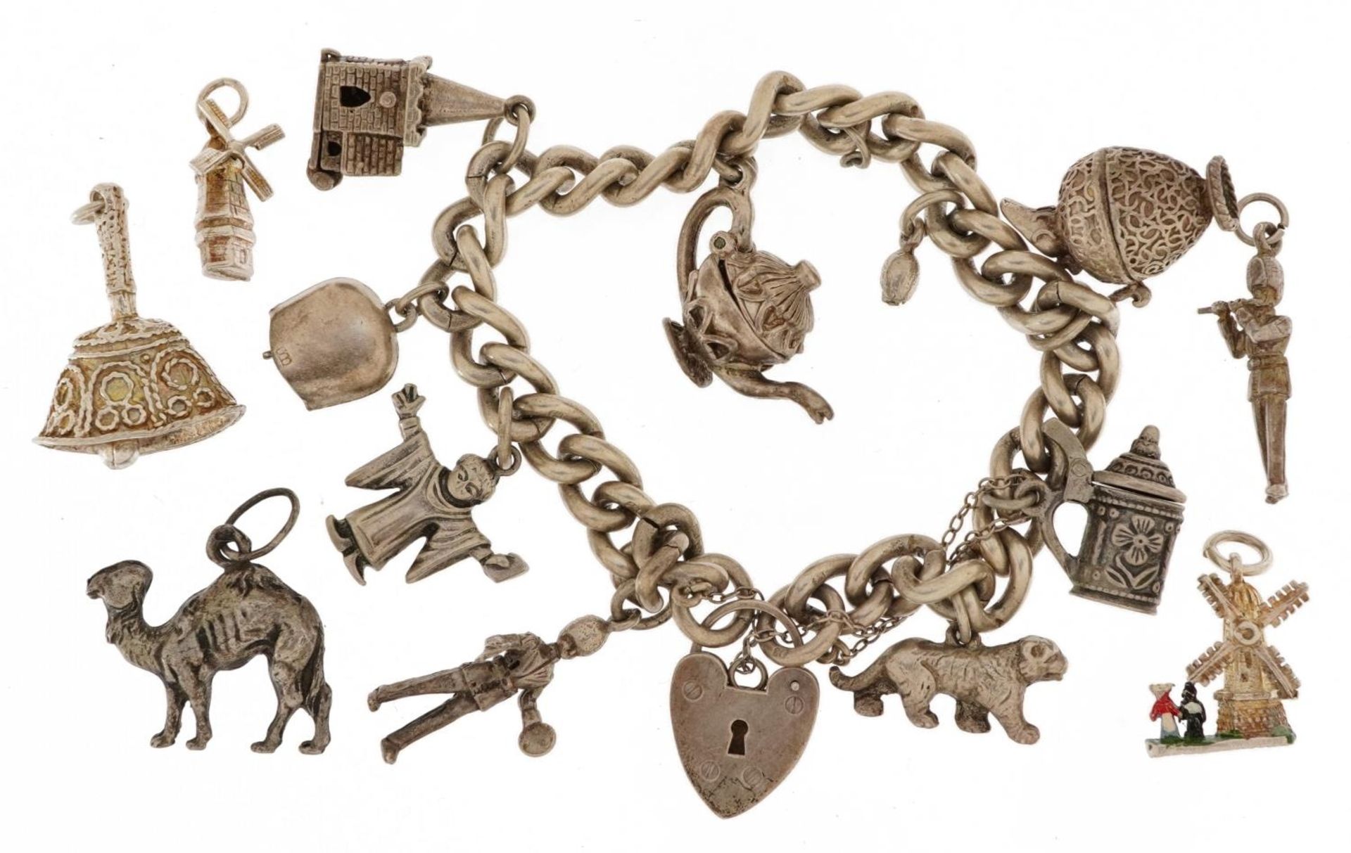 Silver charm bracelet with a selection of mostly silver charms including enamelled windmill, opening