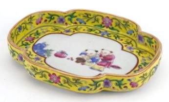 Chinese porcelain four footed dish with yellow ground border hand painted in the famille rose