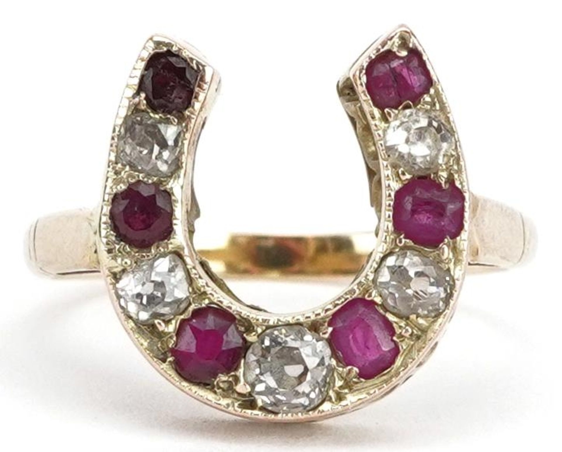 Unmarked gold diamond and ruby horseshoe ring, tests as 15ct gold, the largest diamond approximately