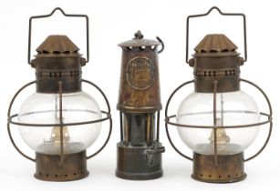 Vintage brass Eccles miner's lamp and a pair of globular glass and brass oil lamps, the largest 25cm