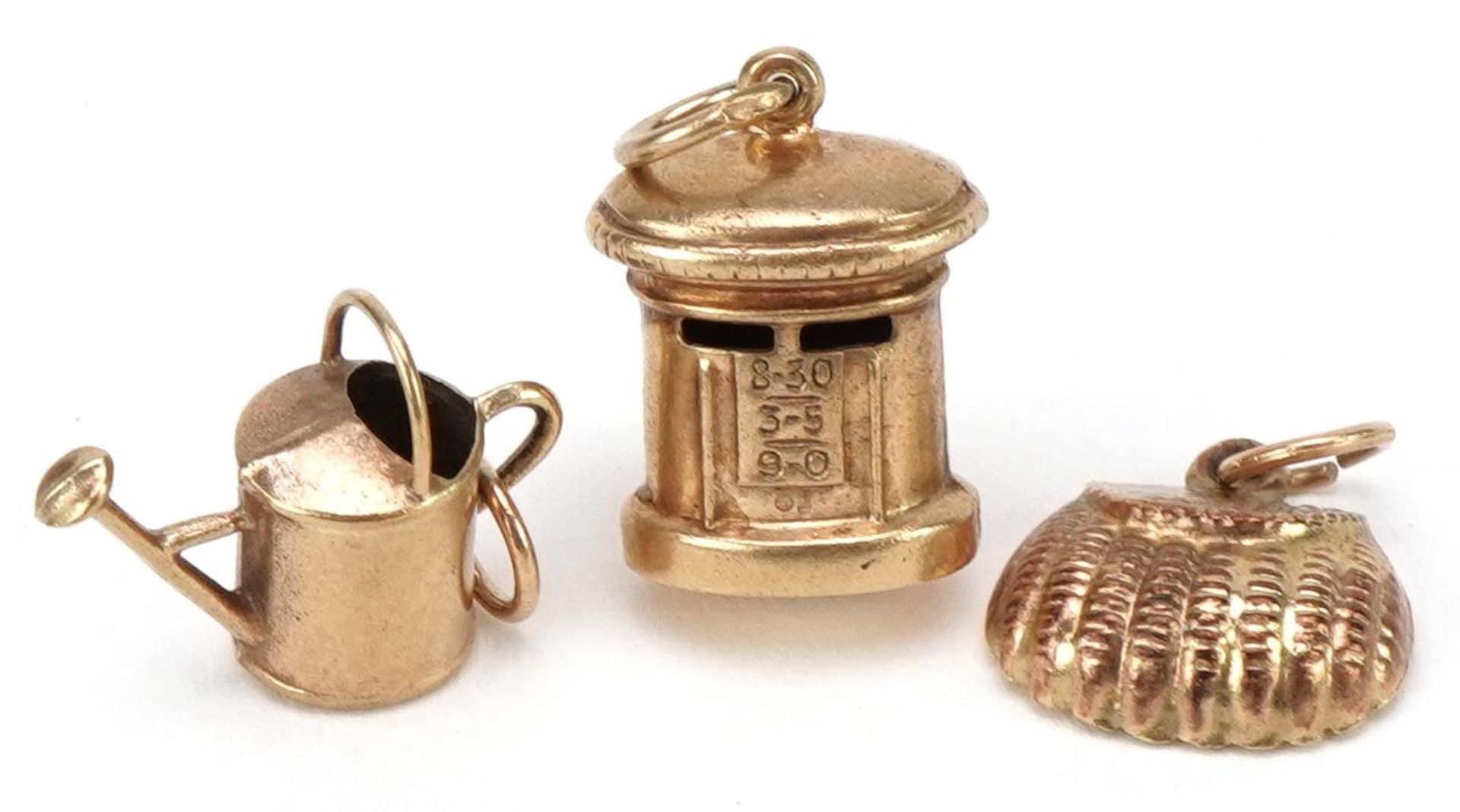 Three 9ct gold charms comprising handbag, postbox and watering can, the largest 1.6cm high, total