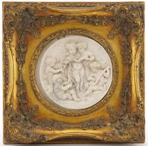 Circular classical marble style plaque decorated in relief with Putti in an ornate gilt frame,