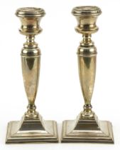 Pair of George V silver candlesticks with square stepped bases, indistinct maker's mark Birmingham