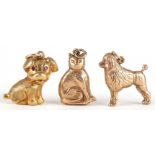 Three 9ct gold animal charms comprising Poodle, seated cat and seated dog with ruby eyes, the