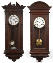 Two 19th century oak Vienna wall clocks having enamelled dials with Roman numerals, the largest 83.