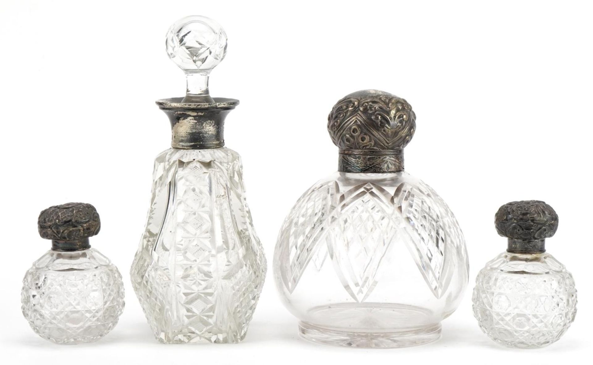 Four Victorian and later cut glass scent bottles with silver lids and mounts, the largest 17cm