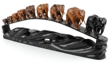 African ebony stand surmounted with nine graduated hardwood elephants entitled Ceylon, 78cm in