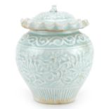 Chinese or Korean porcelain jar and cover having a celadon glaze decorated in low relief with flower