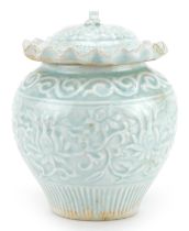 Chinese or Korean porcelain jar and cover having a celadon glaze decorated in low relief with flower