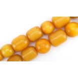 Large amber coloured bead necklace, the largest beads approximately 31mm x 25mm in diameter, 86cm in