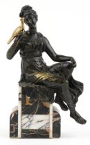 Classical partially gilt patinated bronze figure of a female holding a bird raised on a marble base,