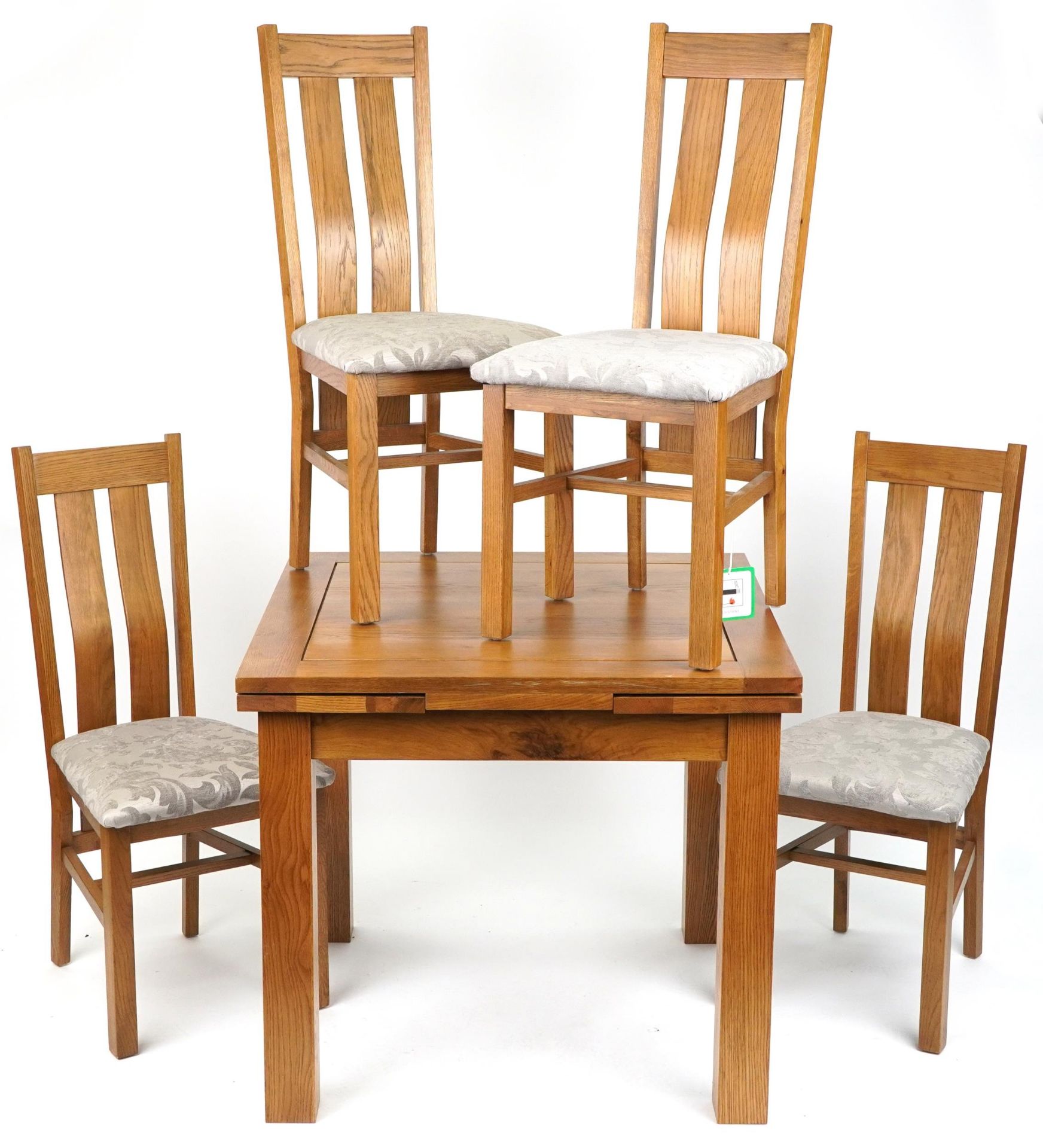 Contemporary golden oak extending dining table with four chairs having floral upholstered cushion