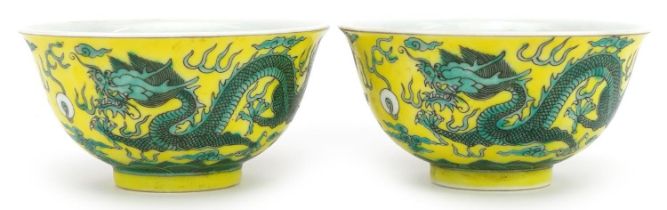 Pair of Chinese yellow ground porcelain bowls hand painted with dragons chasing the flaming pearl