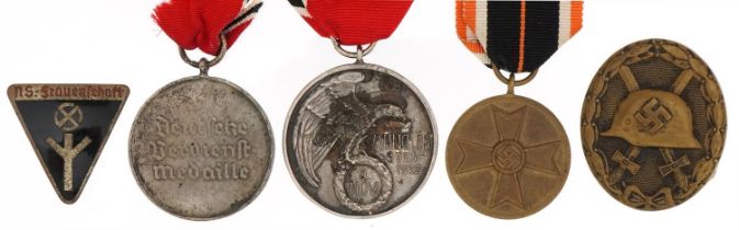 Five German military interest medals/badges including Wounds badge and NS-Frauenschaft membership