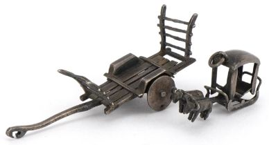 Asian unmarked silver miniature cart and a buffalo drawn cart charm, the largest 5.5cm in length,